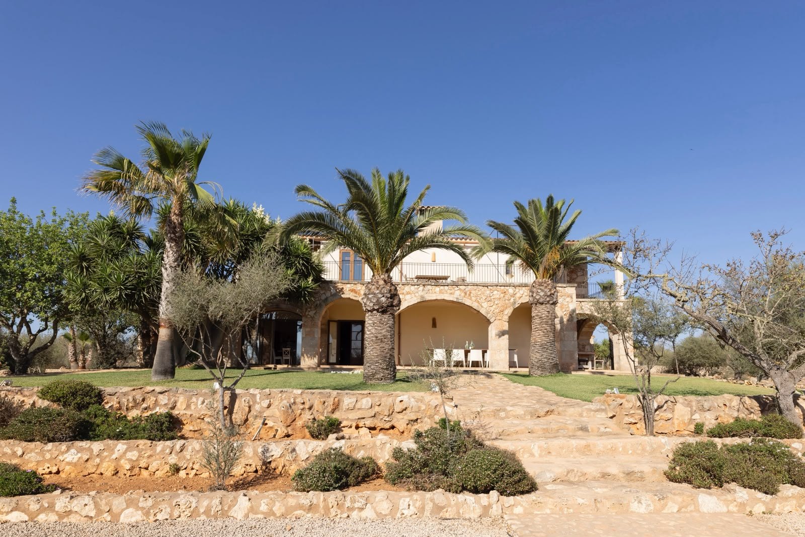 Die Finca auf Mallorca mit Natursteinarkaden und Palmen